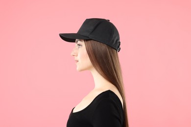 Photo of Beautiful woman in stylish baseball hat on pink background