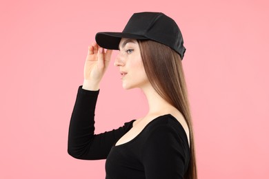 Photo of Beautiful woman in stylish baseball hat on pink background