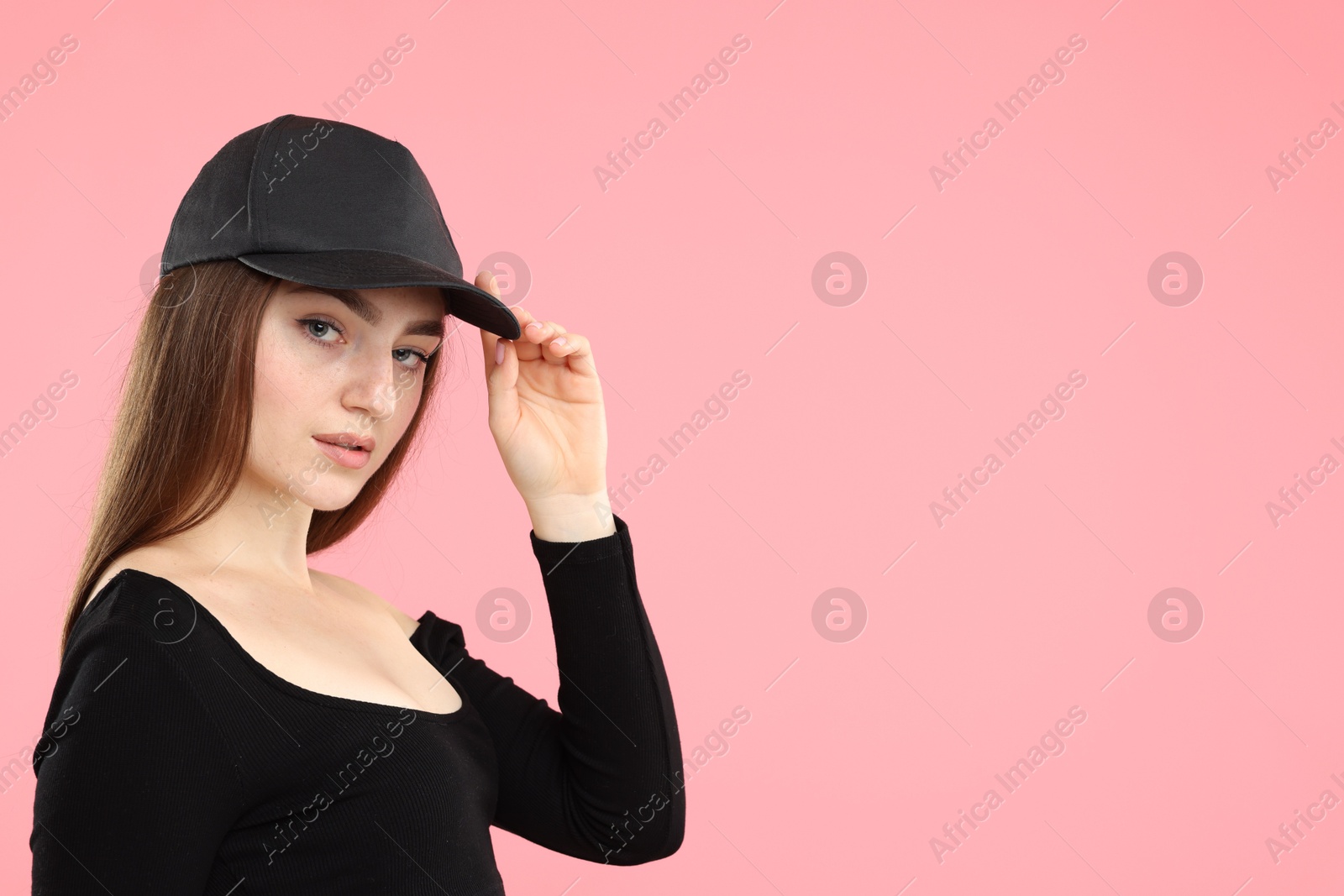 Portrait of beautiful woman in stylish baseball hat on pink background. Space for text Photo of Portrait of beautiful woman in stylish baseball hat on pink background. Space for text