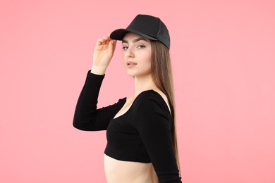 Photo of Portrait of beautiful woman in stylish baseball hat on pink background