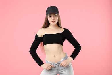 Photo of Portrait of beautiful woman in stylish baseball hat on pink background