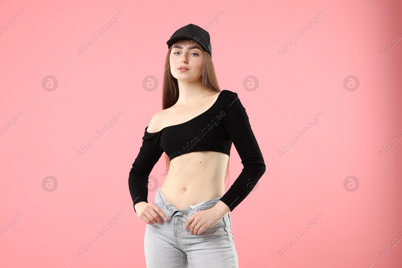 Portrait of beautiful woman in stylish baseball hat on pink background Photo of Portrait of beautiful woman in stylish baseball hat on pink background
