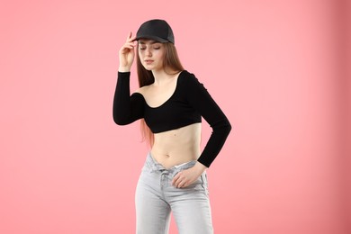 Photo of Portrait of beautiful woman in stylish baseball hat on pink background