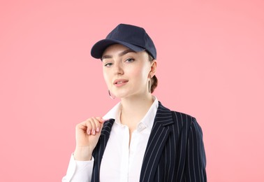 Photo of Portrait of beautiful woman in stylish baseball hat on pink background