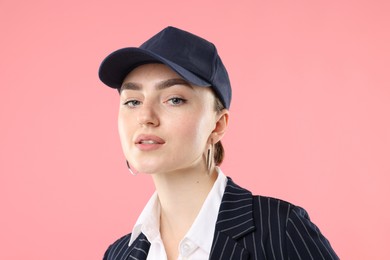 Photo of Portrait of beautiful woman in stylish baseball hat on pink background, closeup