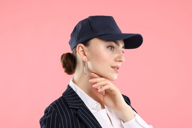 Photo of Beautiful woman in stylish baseball hat on pink background