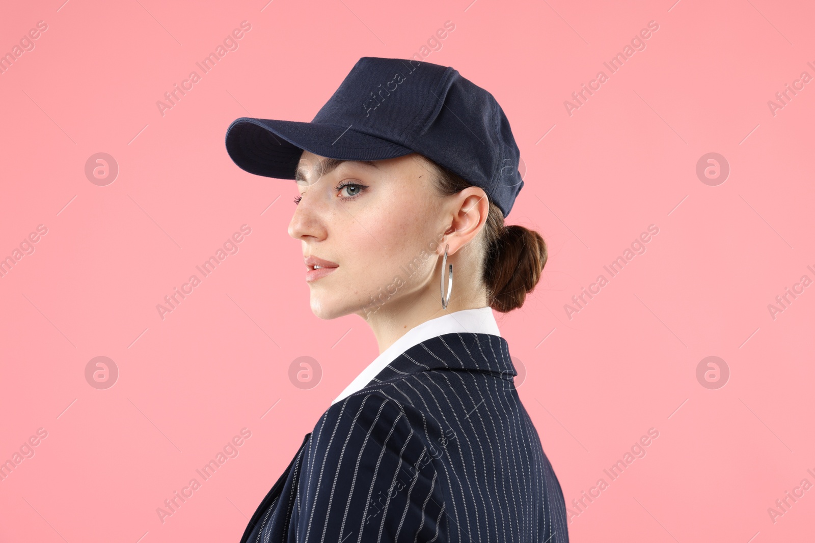Beautiful woman in stylish baseball hat on pink background Photo of Beautiful woman in stylish baseball hat on pink background