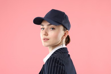 Photo of Portrait of beautiful woman in stylish baseball hat on pink background