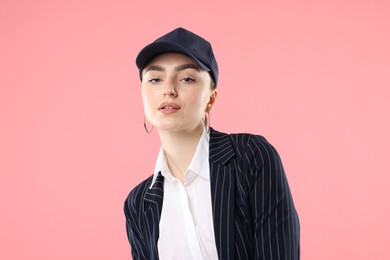 Photo of Portrait of beautiful woman in stylish baseball hat on pink background