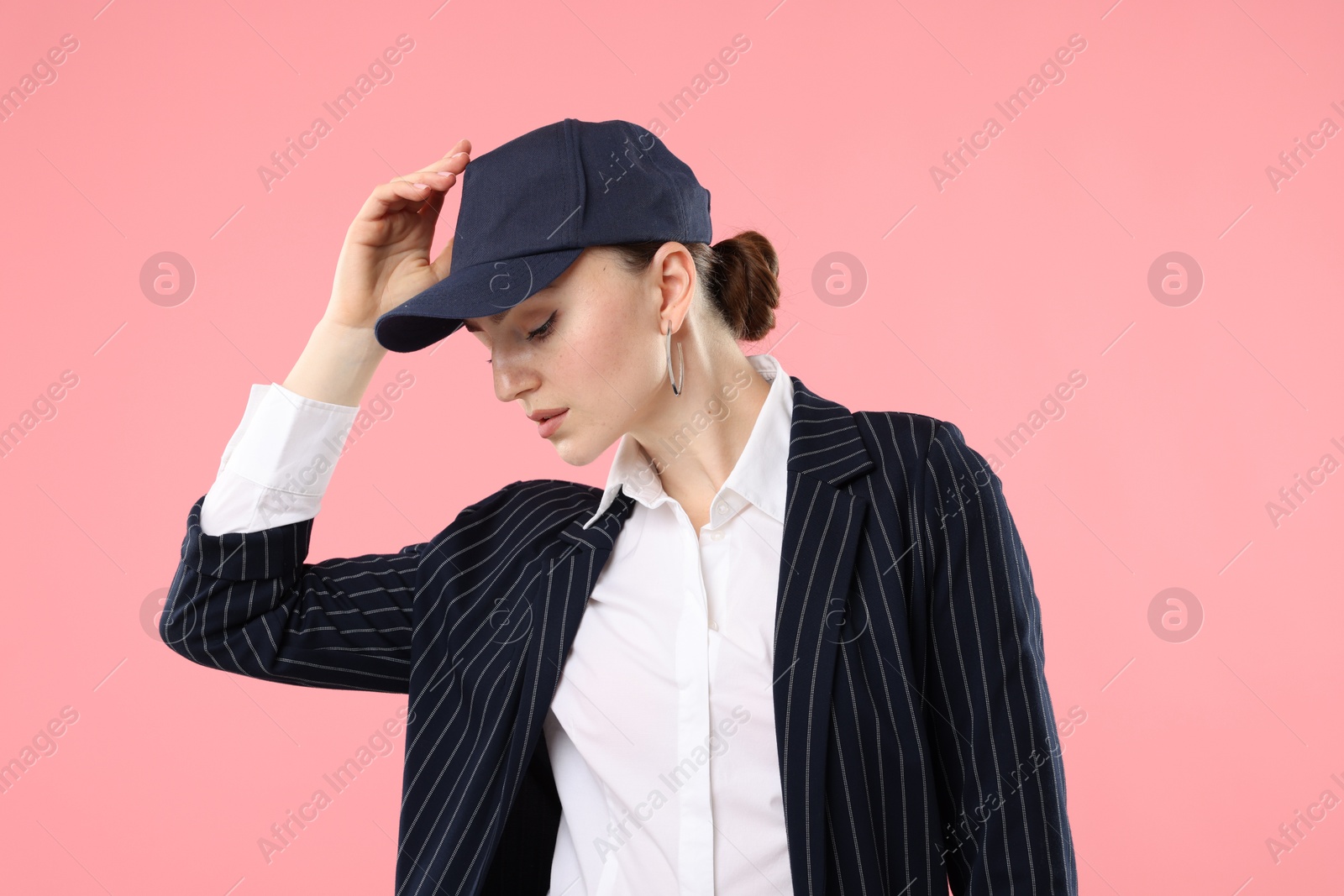 Beautiful woman in stylish baseball hat on pink background Photo of Beautiful woman in stylish baseball hat on pink background
