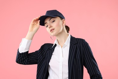 Photo of Portrait of beautiful woman in stylish baseball hat on pink background