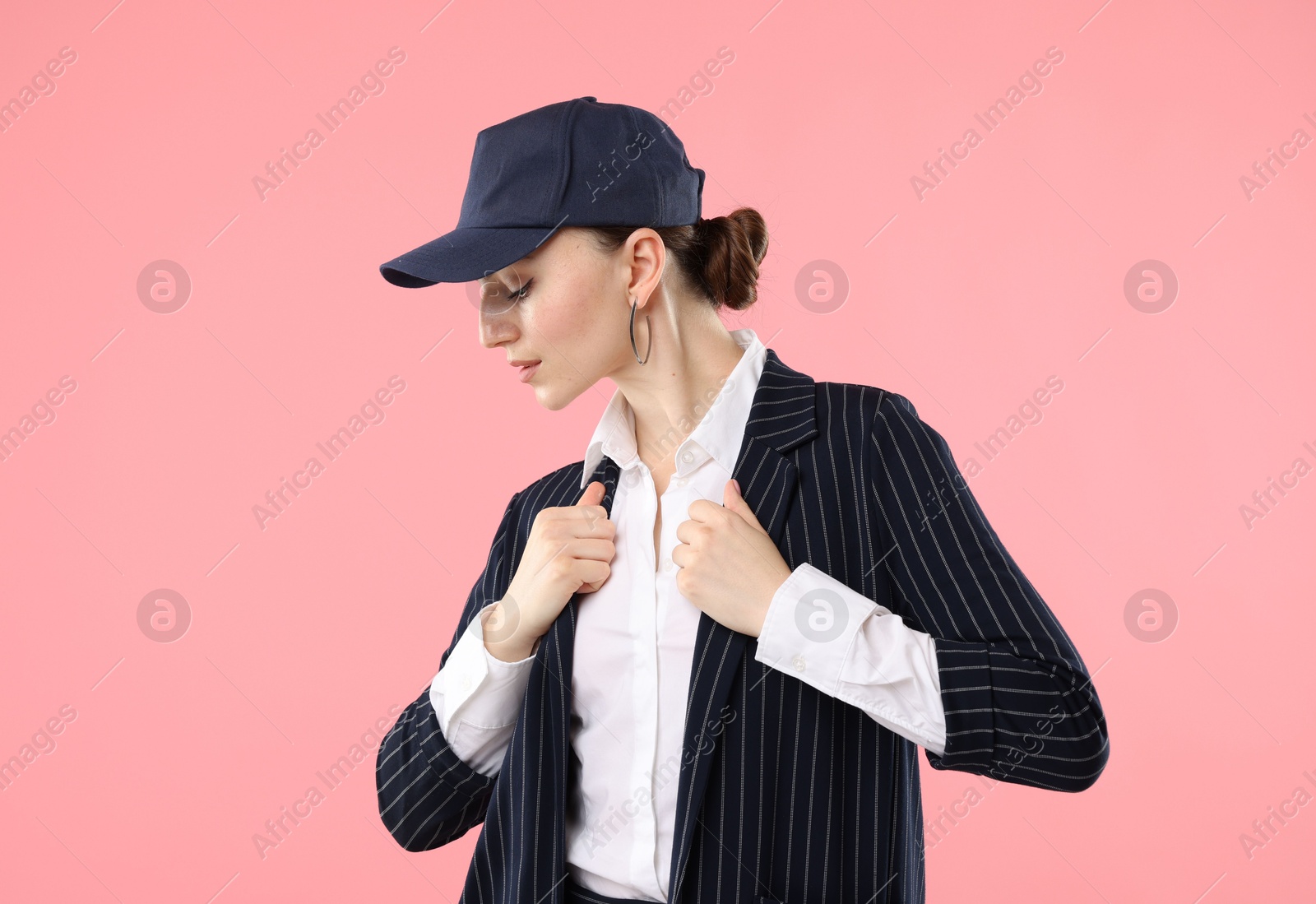 Beautiful woman in stylish baseball hat on pink background Photo of Beautiful woman in stylish baseball hat on pink background