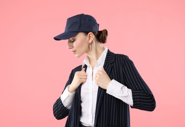 Photo of Beautiful woman in stylish baseball hat on pink background