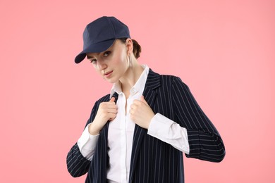 Photo of Portrait of beautiful woman in stylish baseball hat on pink background