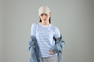 Photo of Portrait of beautiful woman in stylish baseball hat on grey background