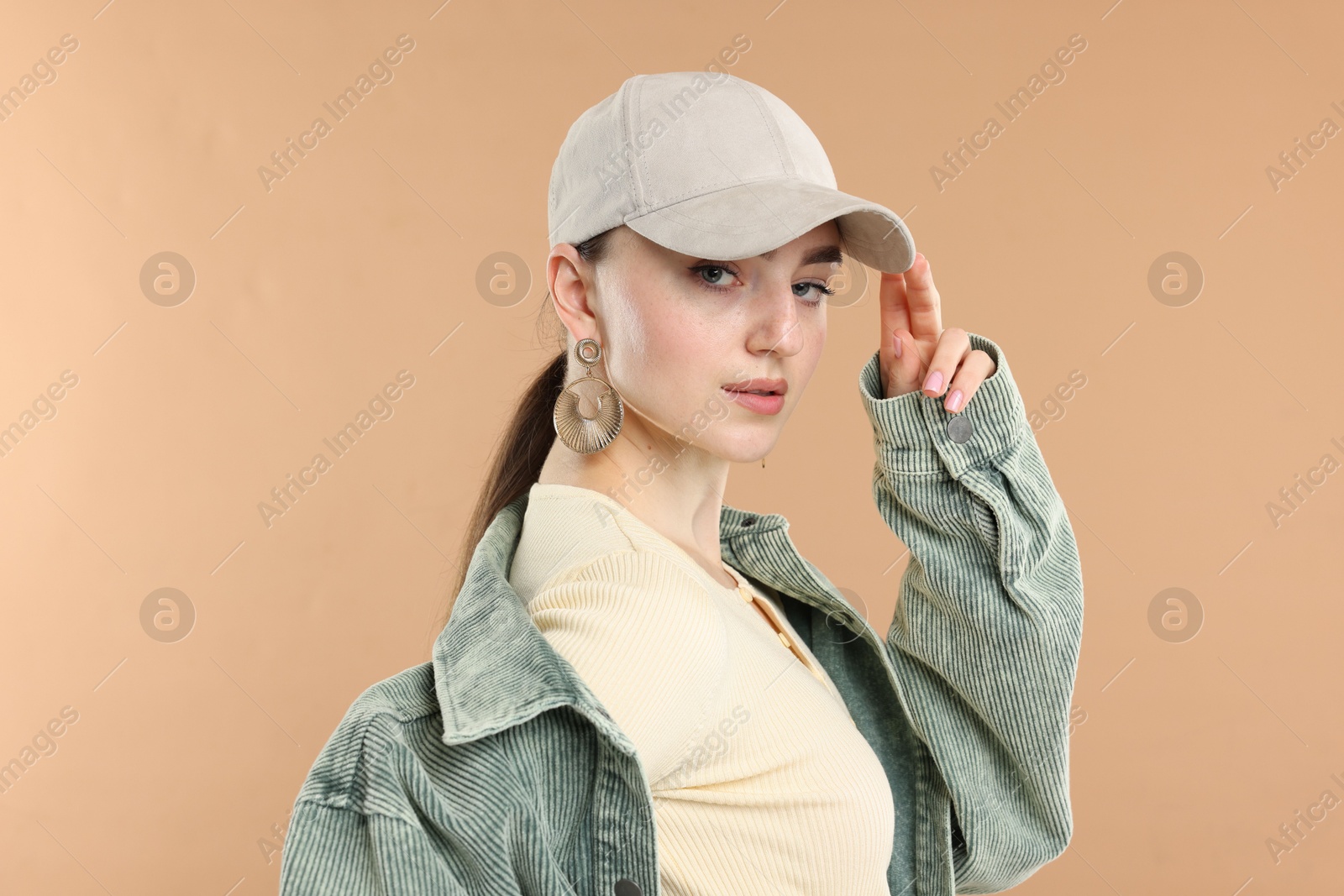 Portrait of beautiful woman in stylish baseball hat on beige background Photo of Portrait of beautiful woman in stylish baseball hat on beige background