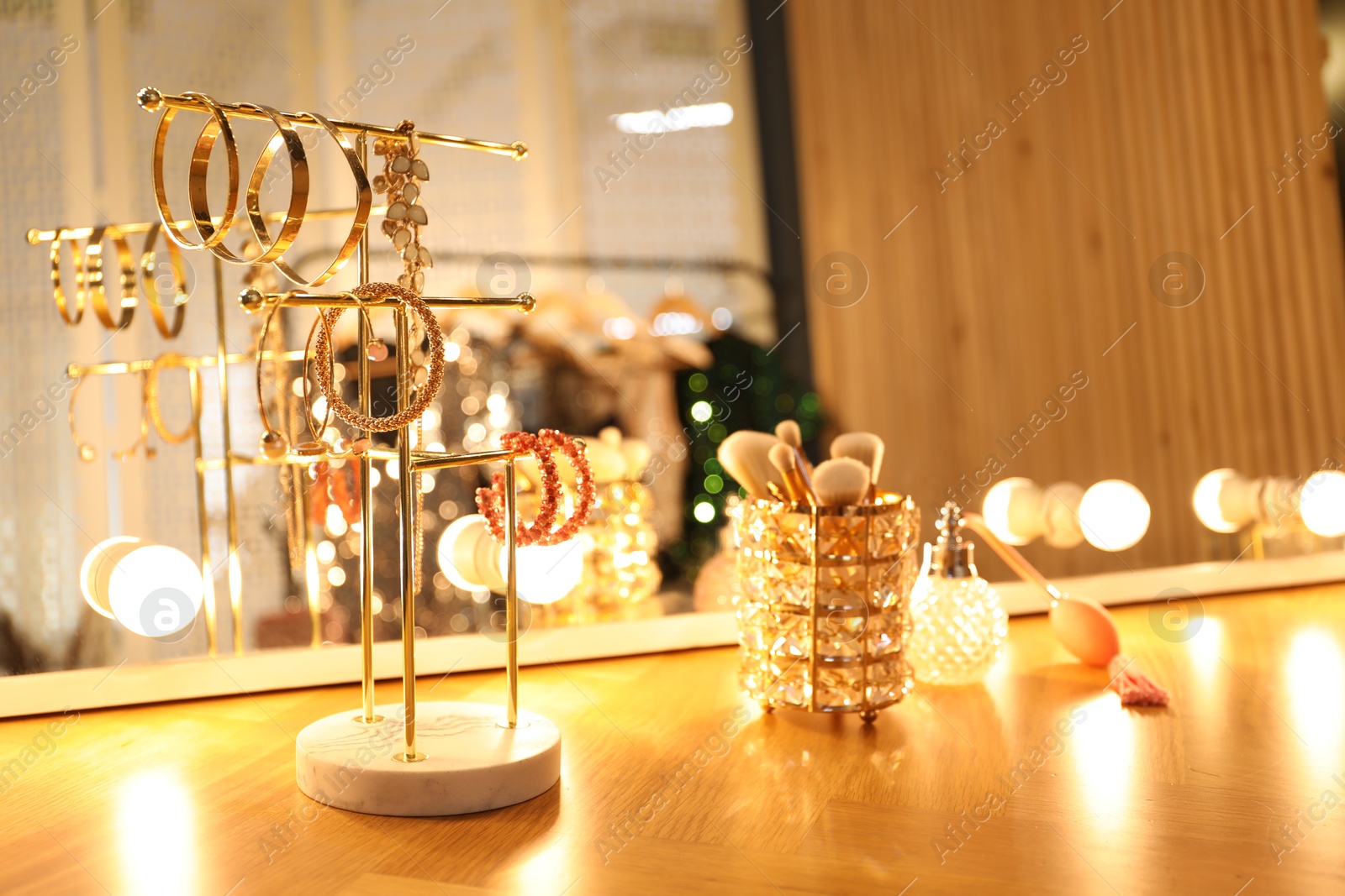 Different accessories and makeup brushes on vanity in dressing room Photo of Different accessories and makeup brushes on vanity in dressing room