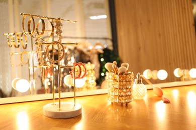 Photo of Different accessories and makeup brushes on vanity in dressing room