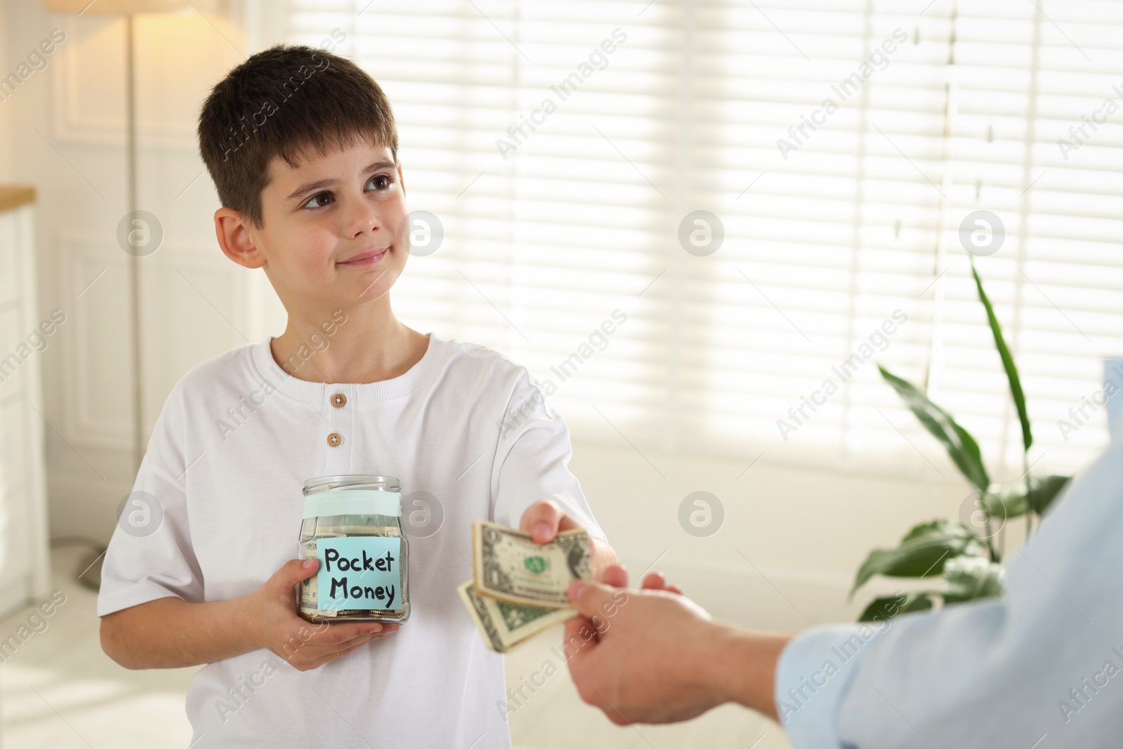 Father giving his son pocket money at home, closeup Photo of Father giving his son pocket money at home, closeup