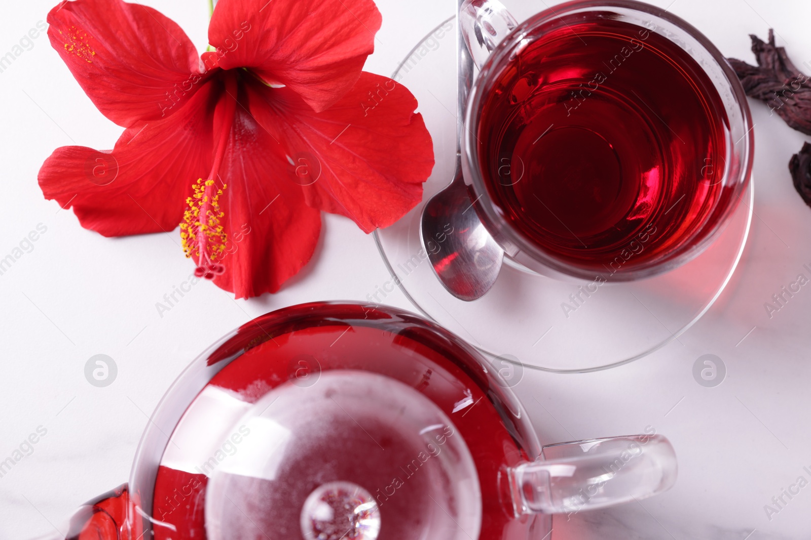 Tasty hibiscus tea and beautiful flower on white table, flat lay Photo of Tasty hibiscus tea and beautiful flower on white table, flat lay