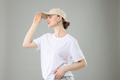 Photo of Beautiful woman in stylish baseball hat on grey background