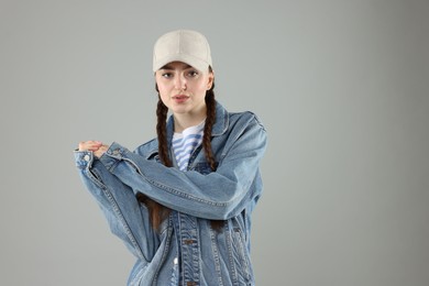Photo of Portrait of beautiful woman in stylish baseball hat on grey background