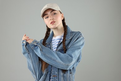 Photo of Portrait of beautiful woman in stylish baseball hat on grey background