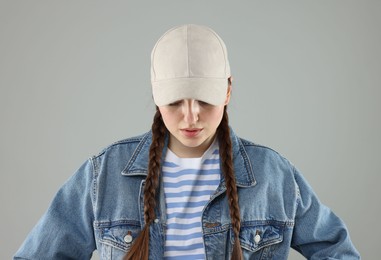 Photo of Woman in stylish baseball hat on grey background