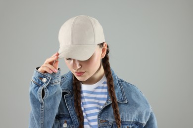 Photo of Woman in stylish baseball hat on grey background