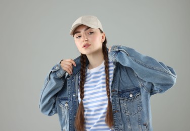 Photo of Beautiful woman in stylish baseball hat on grey background