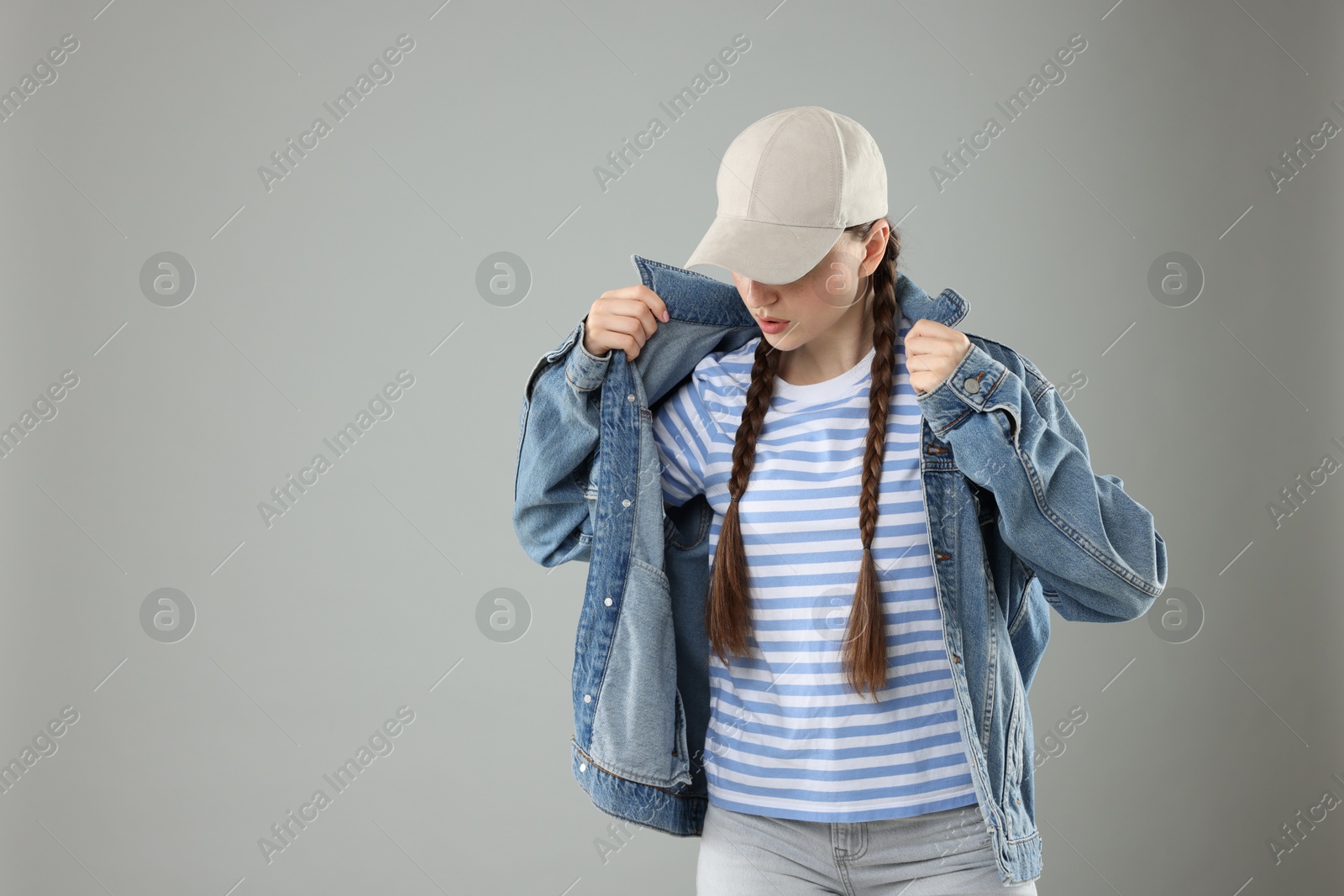 Beautiful woman in stylish baseball hat on grey background. Space for text Photo of Beautiful woman in stylish baseball hat on grey background. Space for text