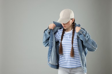 Photo of Beautiful woman in stylish baseball hat on grey background. Space for text