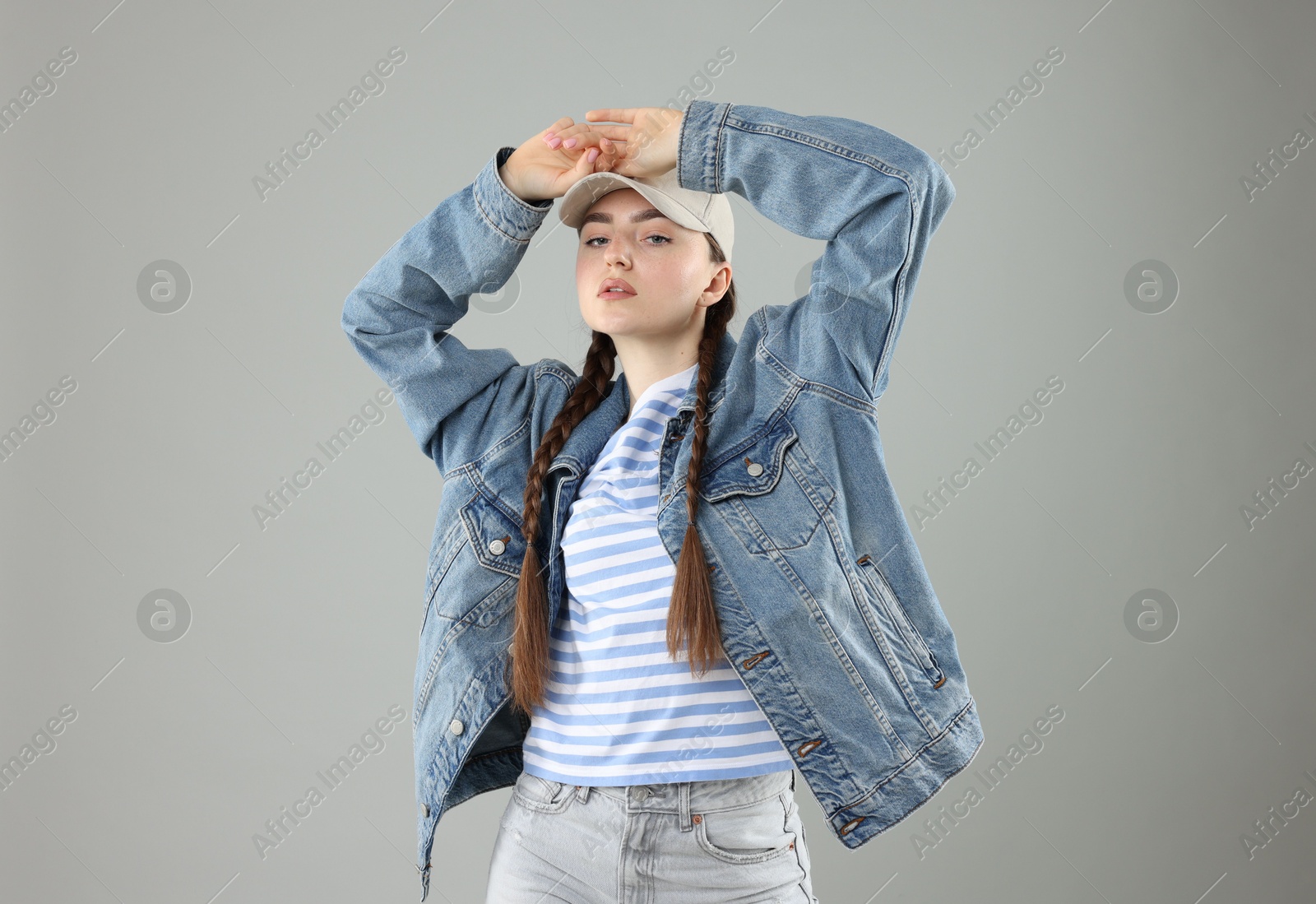 Beautiful woman in stylish baseball hat on grey background Photo of Beautiful woman in stylish baseball hat on grey background