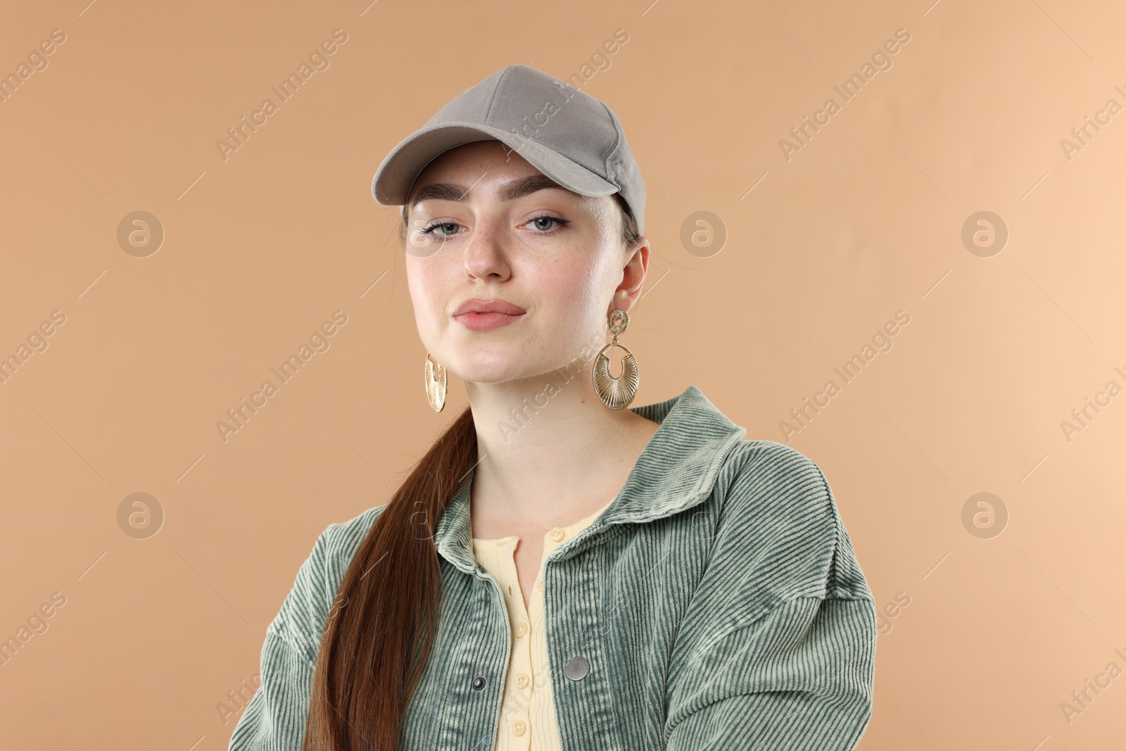Portrait of beautiful woman in stylish baseball hat on beige background Photo of Portrait of beautiful woman in stylish baseball hat on beige background