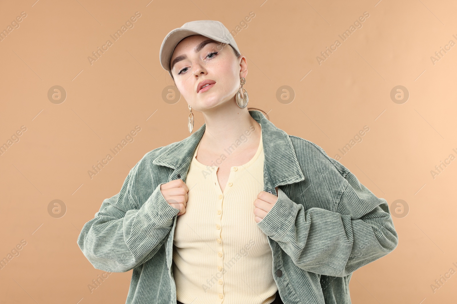 Portrait of beautiful woman in stylish baseball hat on beige background Photo of Portrait of beautiful woman in stylish baseball hat on beige background