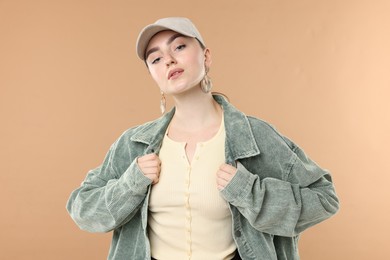 Photo of Portrait of beautiful woman in stylish baseball hat on beige background