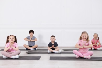 Photo of Group of children practicing yoga on mats in class