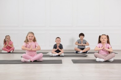 Photo of Group of children practicing yoga on mats in class