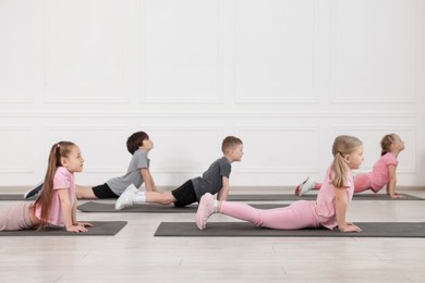 Photo of Group of children practicing yoga on mats in class