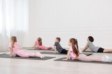 Photo of Group of children practicing yoga on mats in class