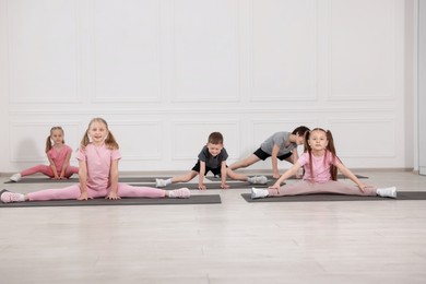 Photo of Group of children practicing yoga on mats in class