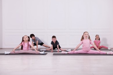 Photo of Group of children practicing yoga on mats in class