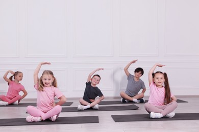 Photo of Group of children practicing yoga on mats in class