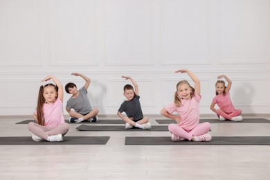Photo of Group of children practicing yoga on mats in class