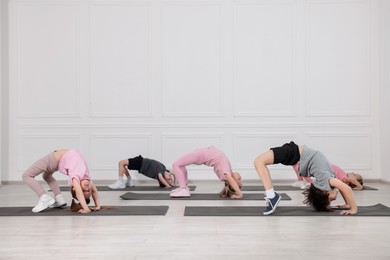 Photo of Group of children practicing yoga on mats in class