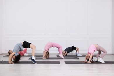 Photo of Group of children practicing yoga on mats in class