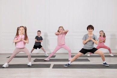 Photo of Group of children practicing yoga on mats in class