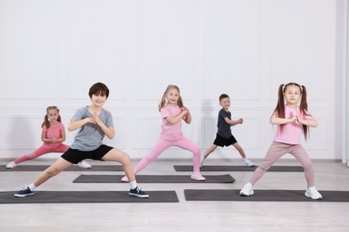 Photo of Group of children practicing yoga on mats in class