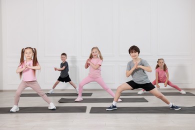 Photo of Group of children practicing yoga on mats in class