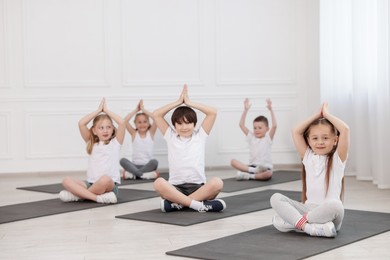 Photo of Group of children practicing yoga on mats in class